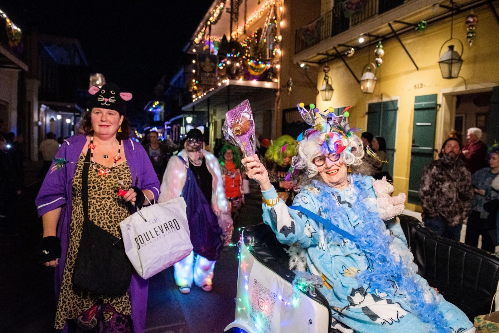 Costumed revelers gathered beneath a French Quarter balcony