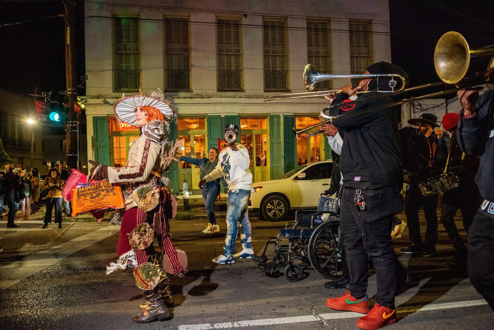 A large sculptural costume passing musicians in the street