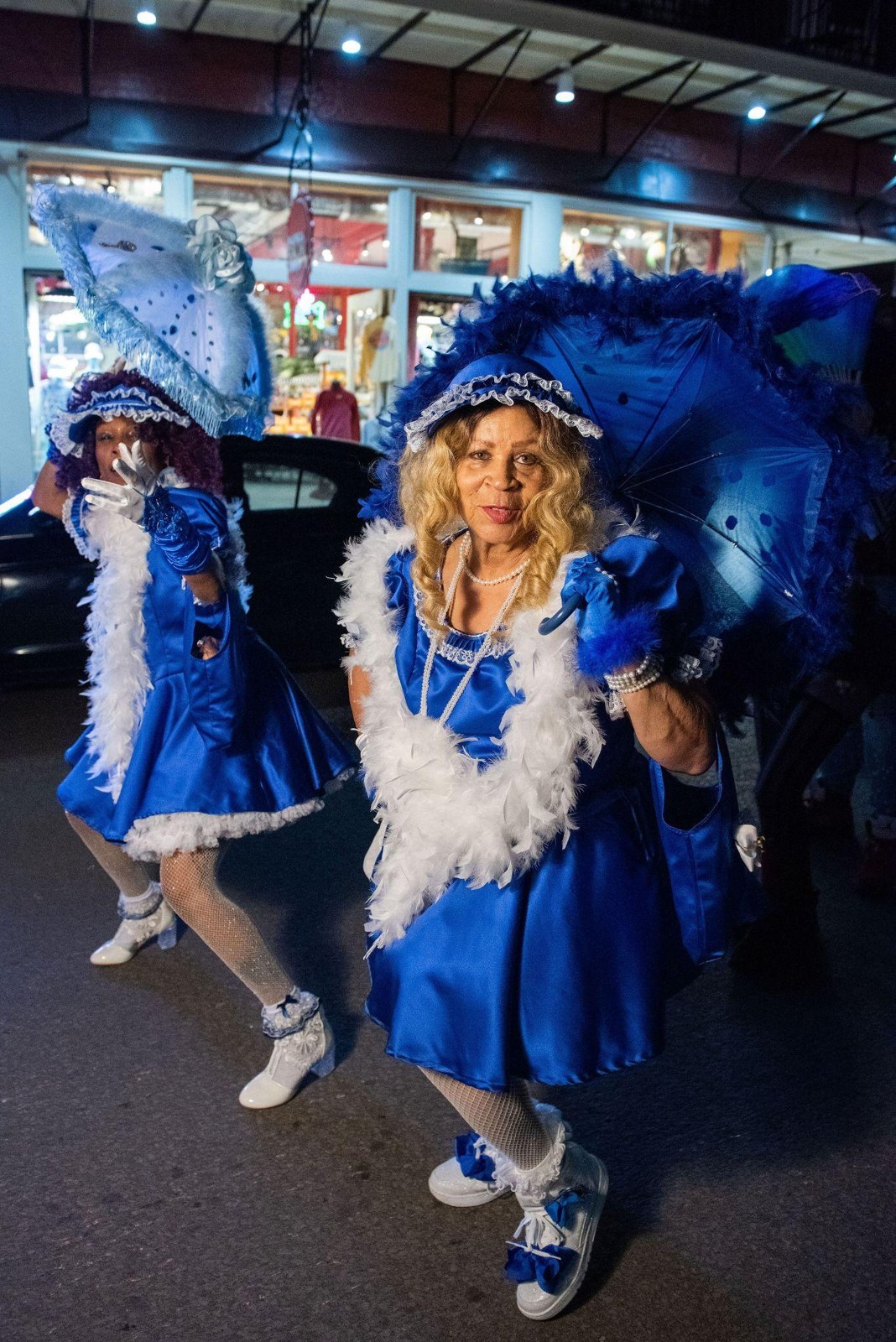 Two revelers wearing elaborate blue and gold costumes